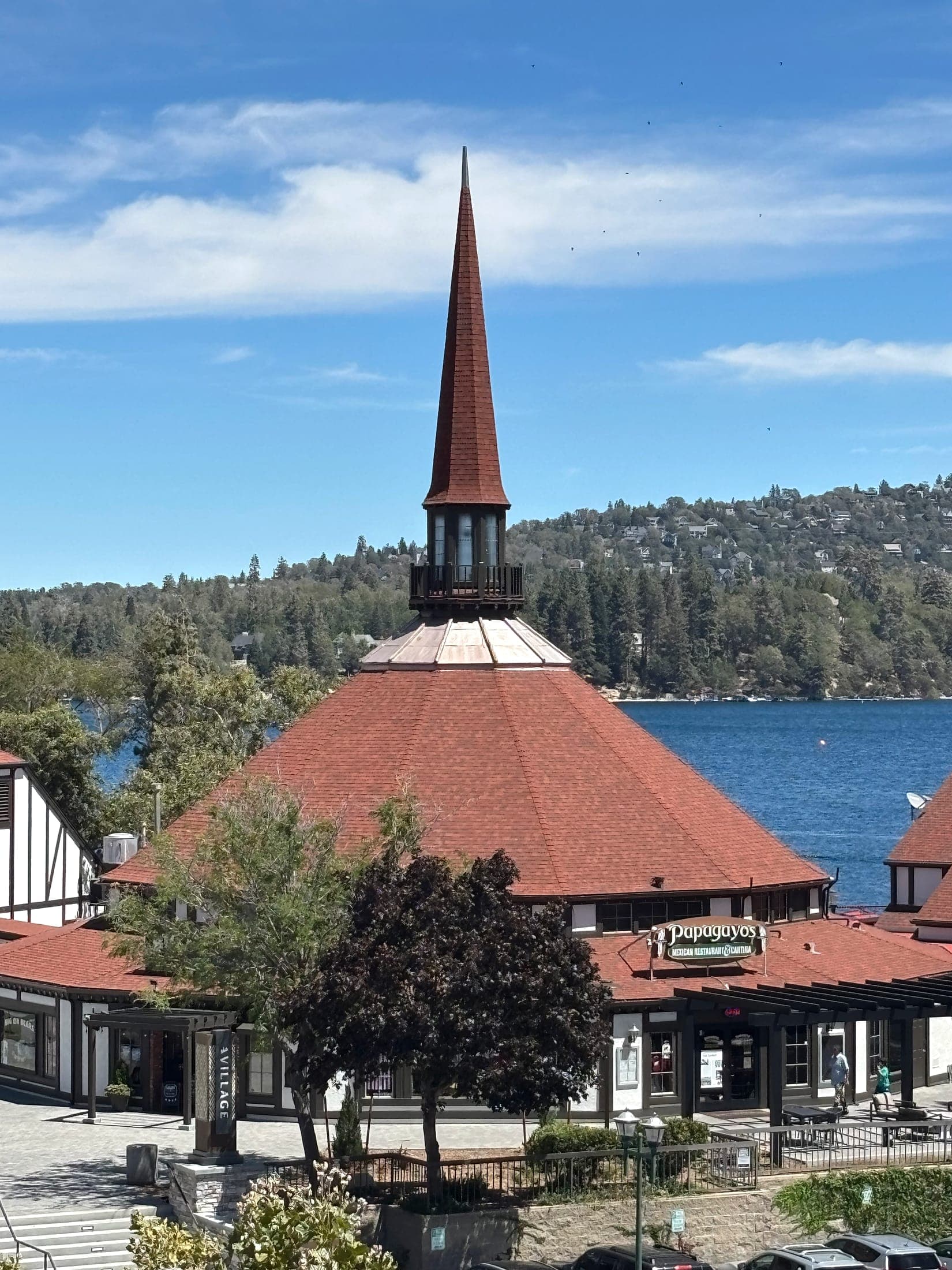 Lake Arrowhead Village restaurant buildings with the lake and forested shoreline behind them