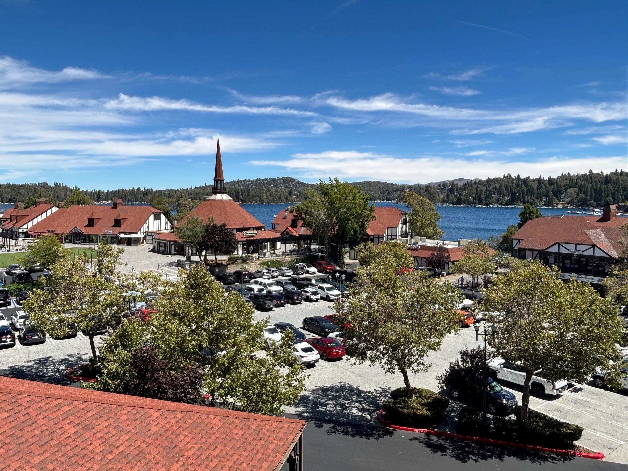 Lake Arrowhead Village shops and parking lot overlooking the lake and forested mountains