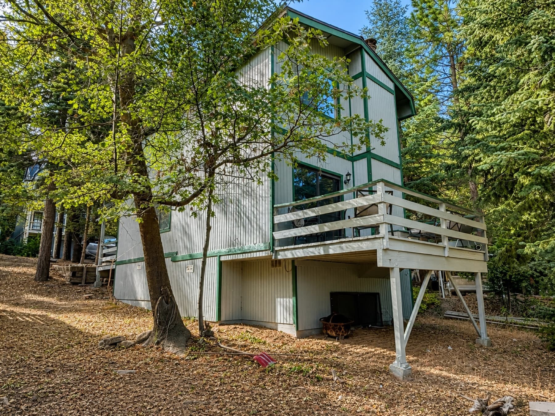 Mountain home with a light-colored deck among pines in Running Springs