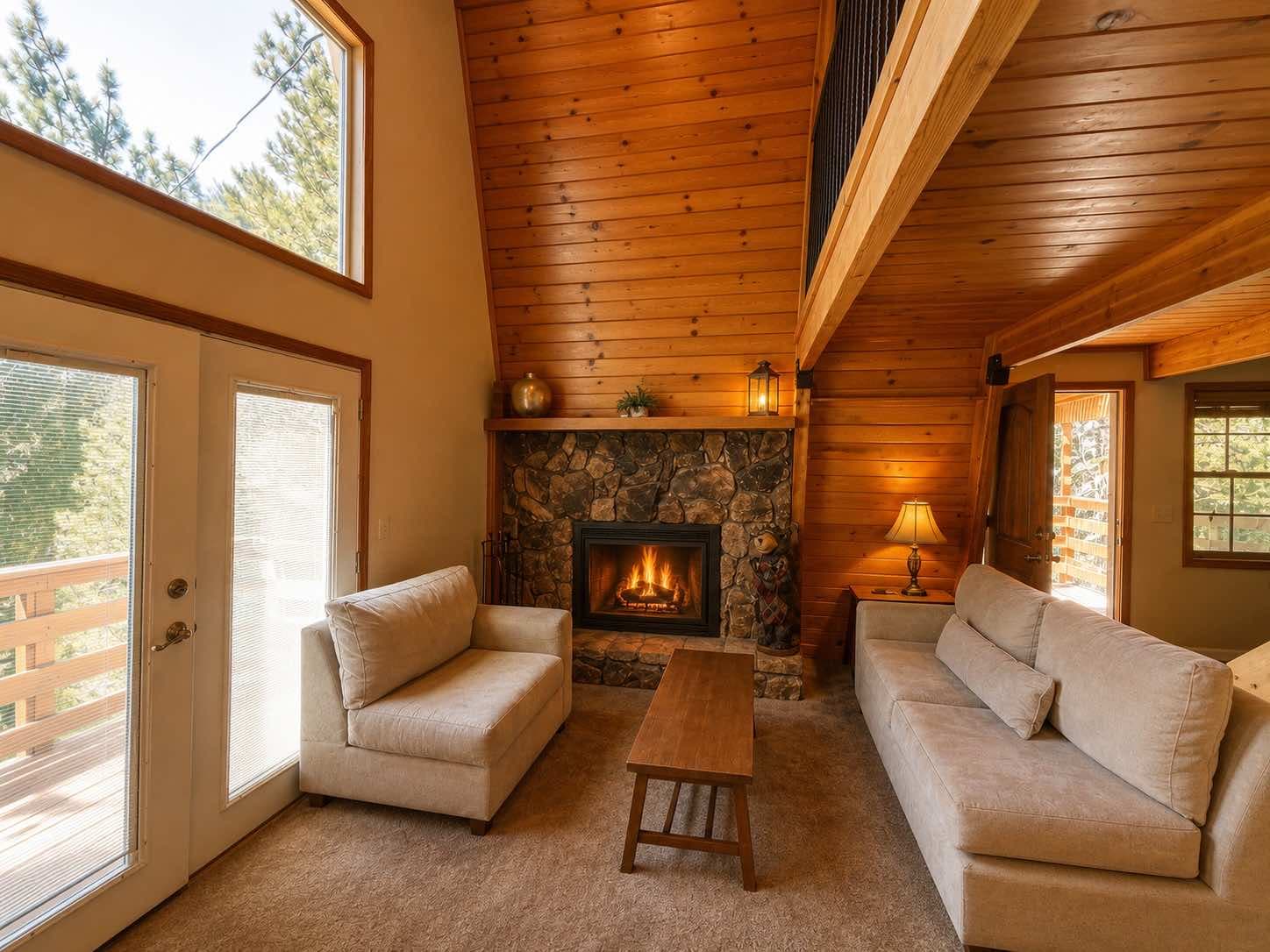 Living room with stone fireplace, wood ceiling, and loft railing at 30975 Knob Hill Circle