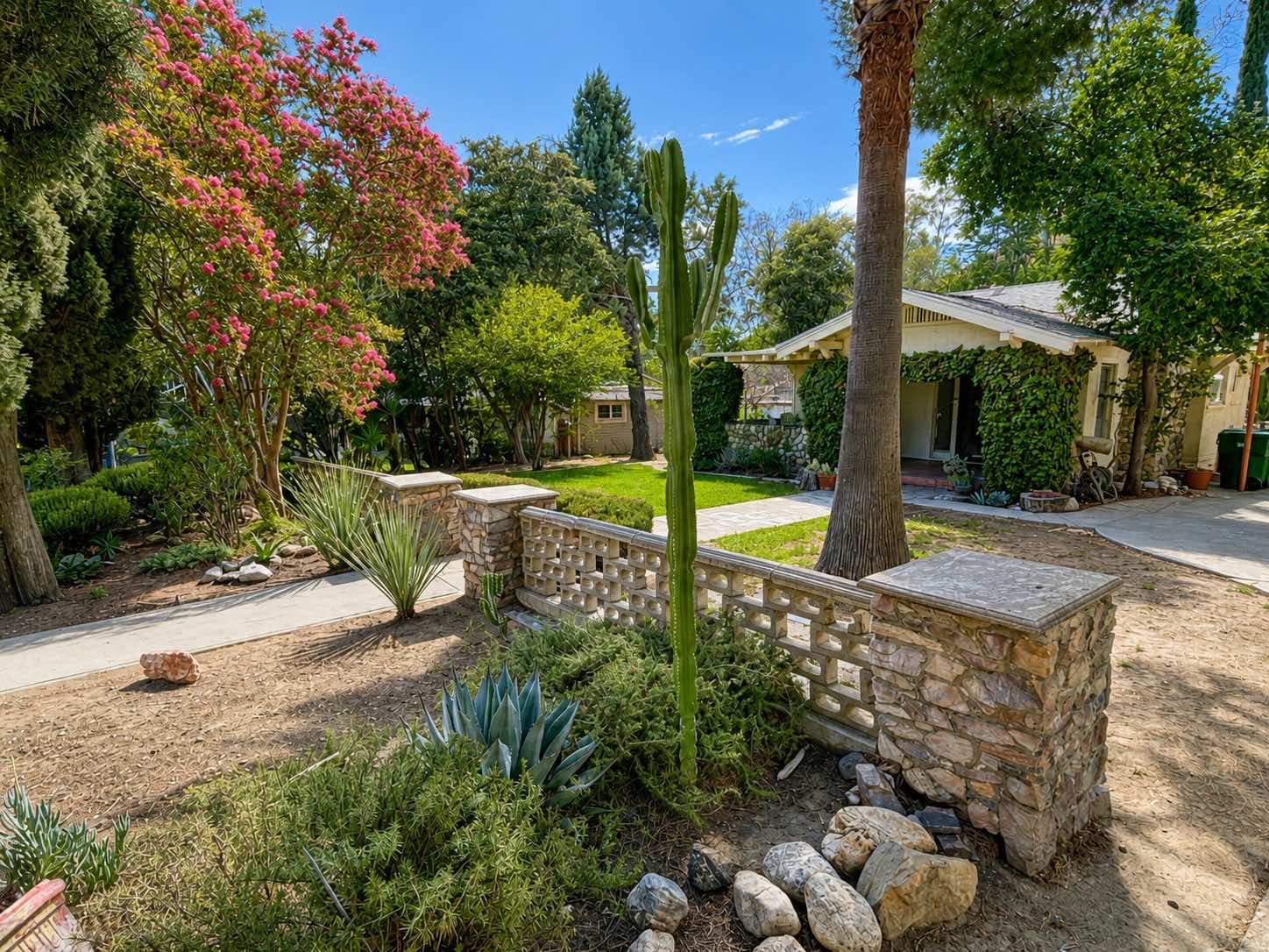 Front garden with succulents, a decorative block wall, and the house beyond at 1951 N San Gorgonio Ave