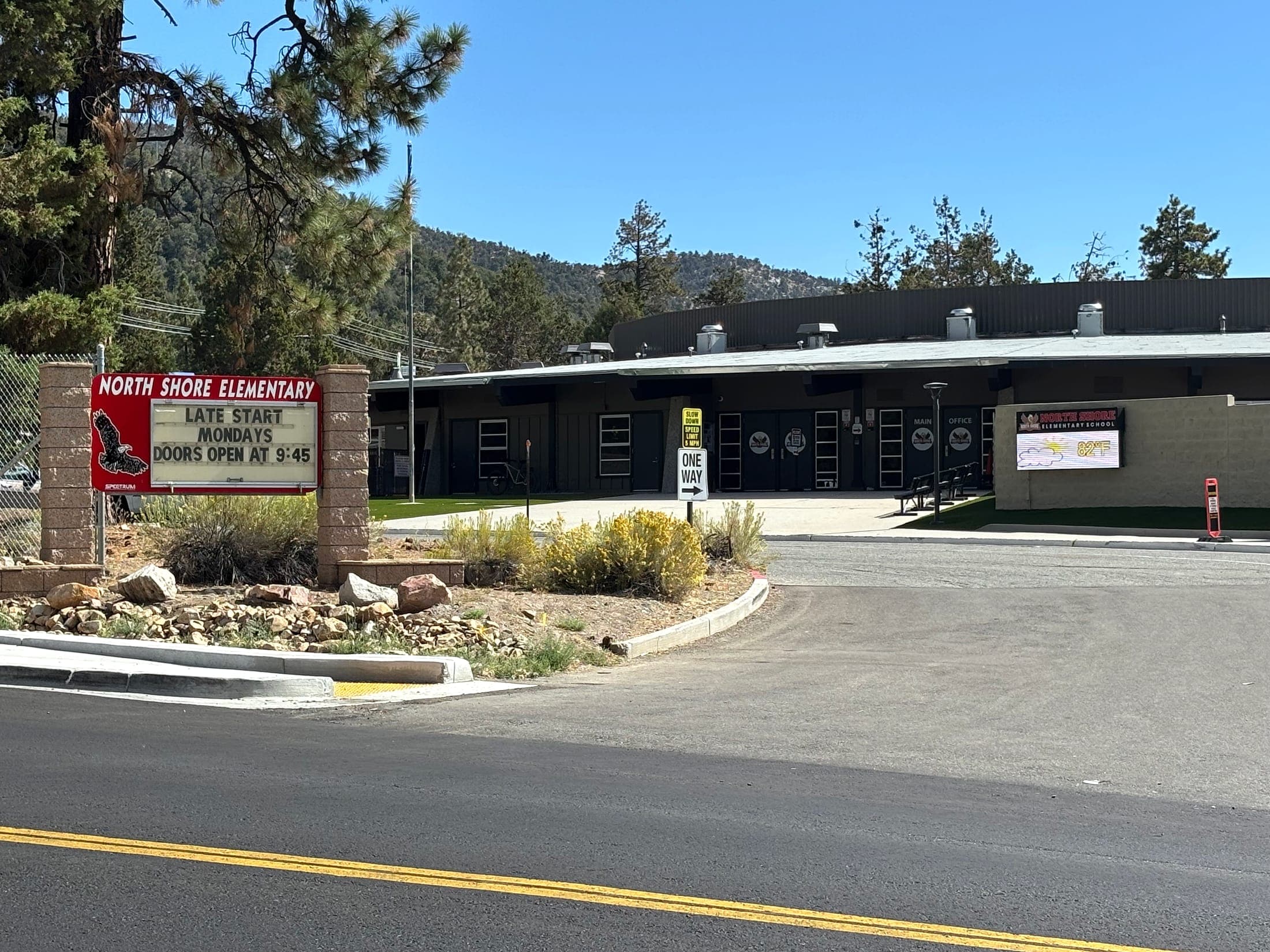 North Shore Elementary School building in Big Bear City, California, with pines and mountains behind