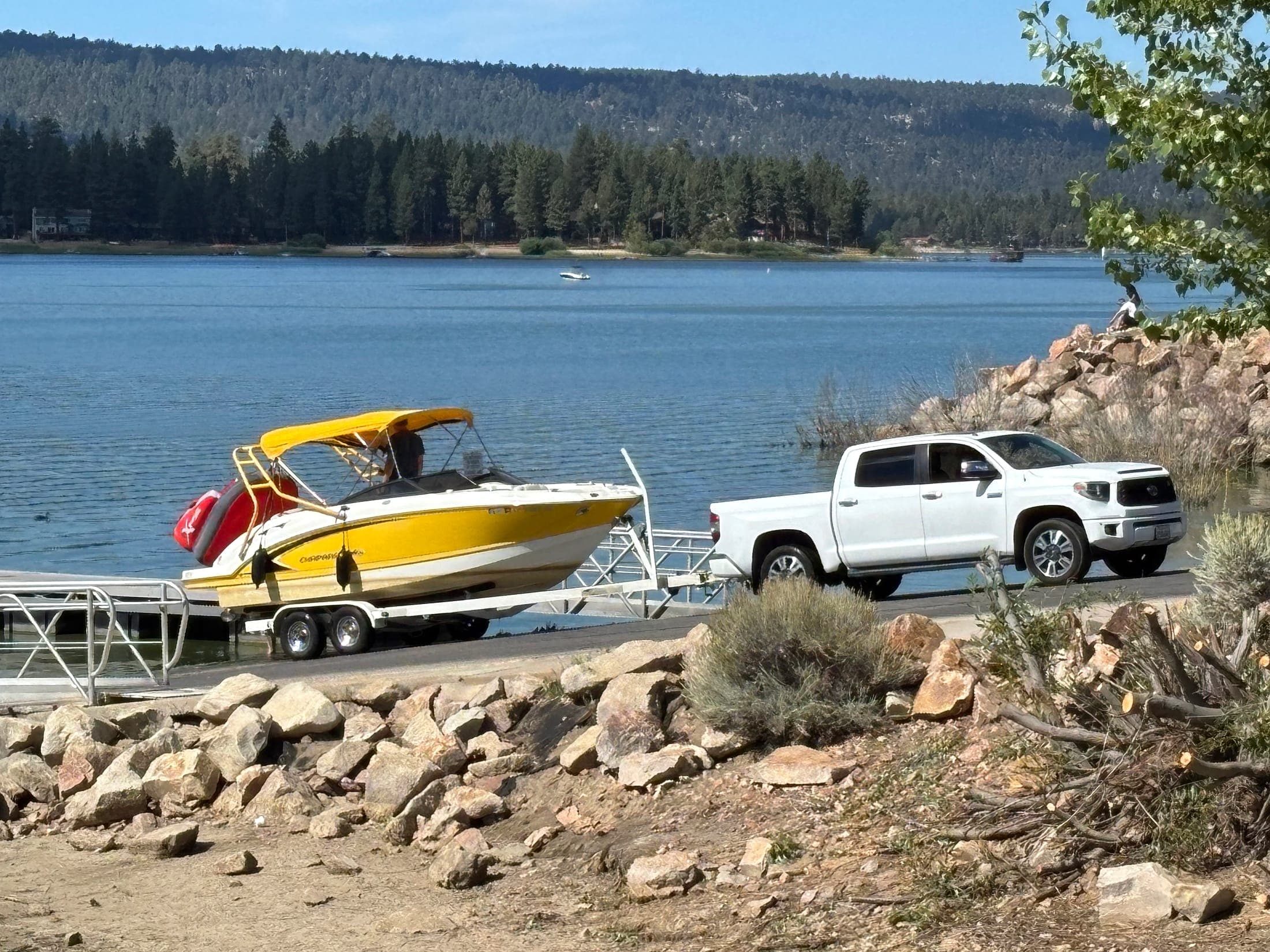 Truck launching a boat at a public ramp on Big Bear Lake with mountains across the water