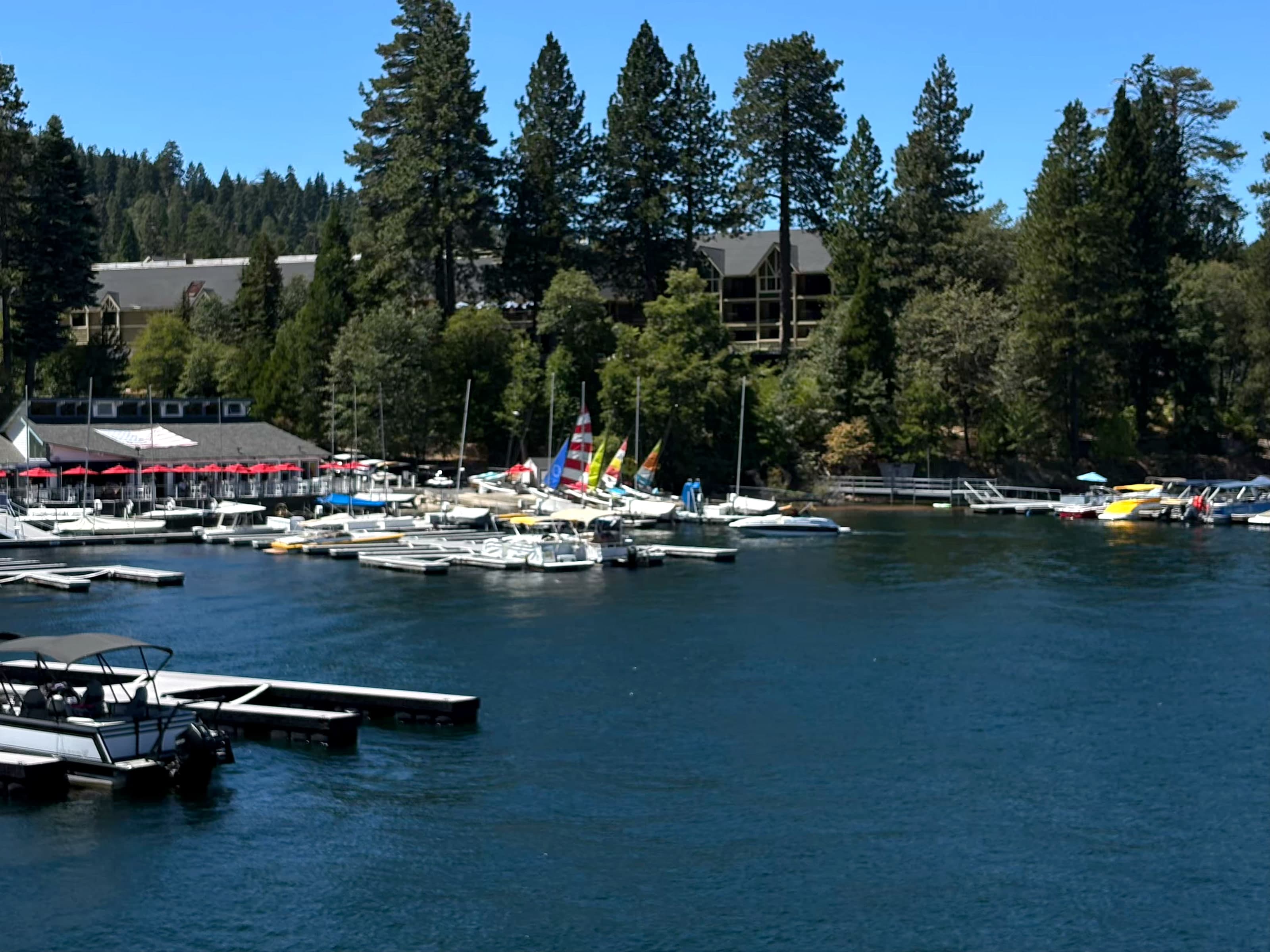 Lake Arrowhead Village harbor with colorful sailboats and red umbrellas