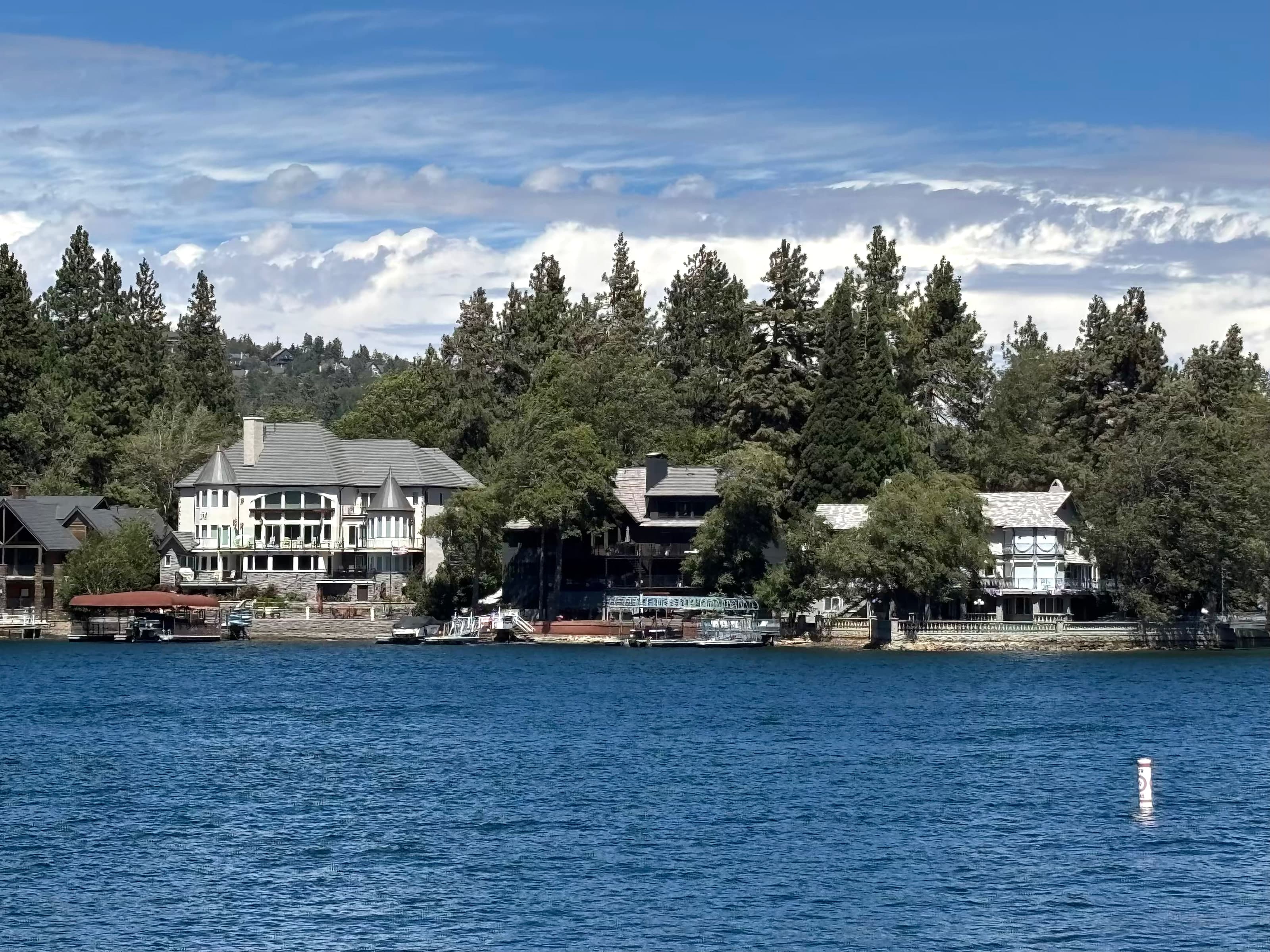 Lakefront mountain homes and docks on Lake Arrowhead seen from the water.