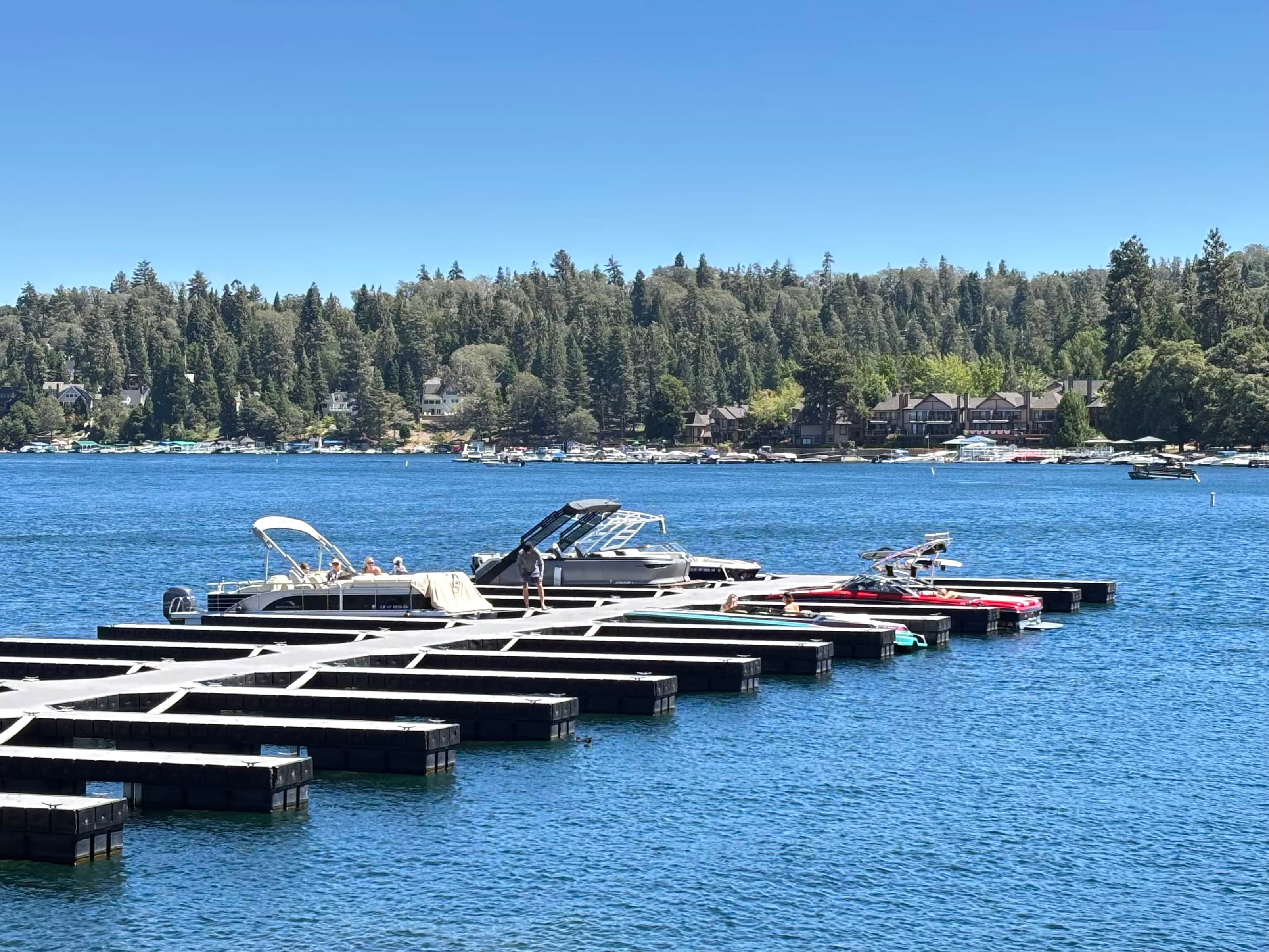 Private boat slips and recreational boats on Lake Arrowhead with forested homes behind
