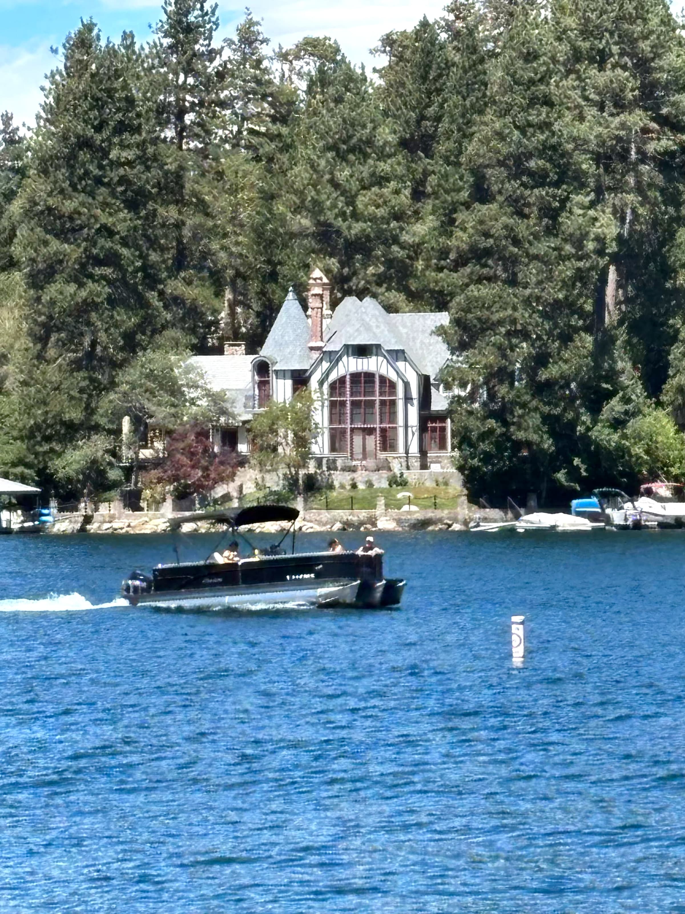 Tudor-style Lake Arrowhead house among pines seen from the lake