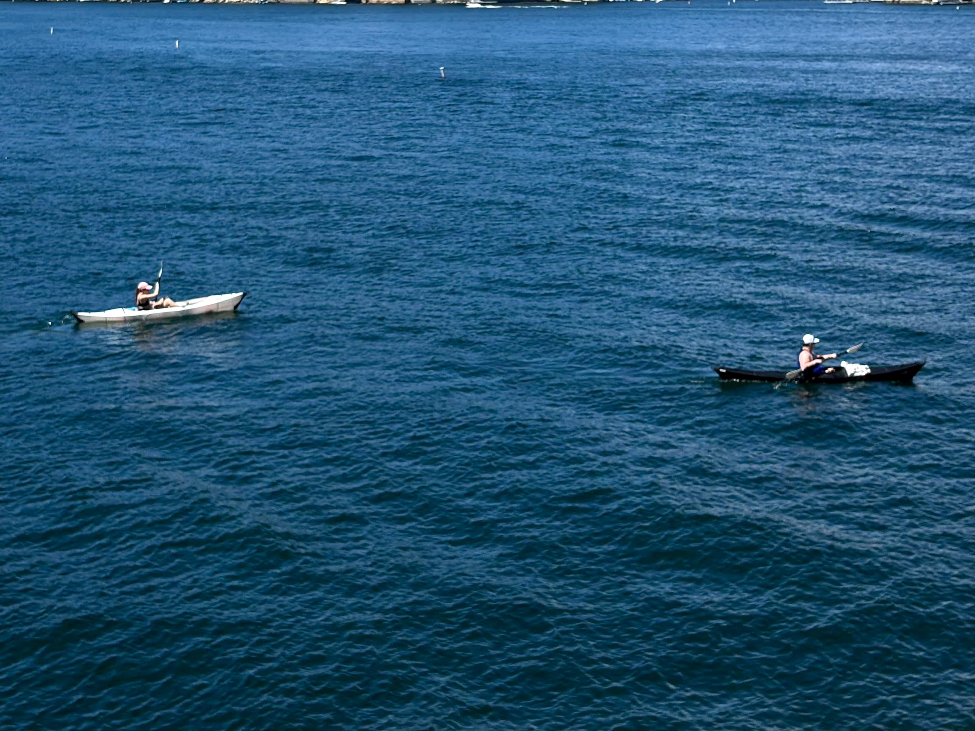 Two kayakers paddling on the open blue water of Lake Arrowhead