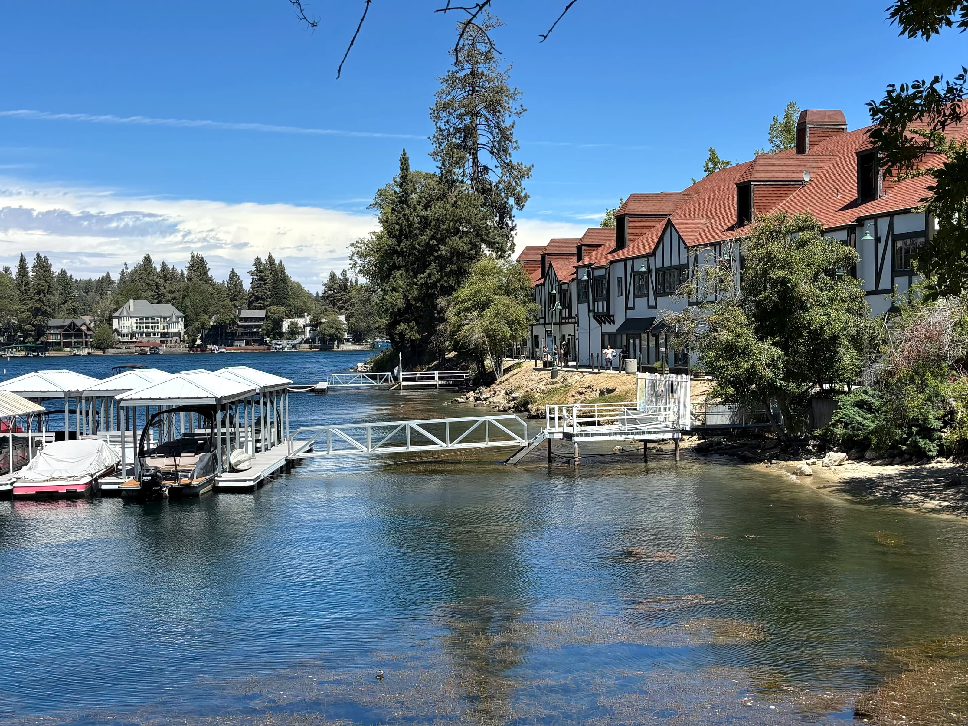 Covered docks beside Tudor Lake Arrowhead Village buildings on the lake