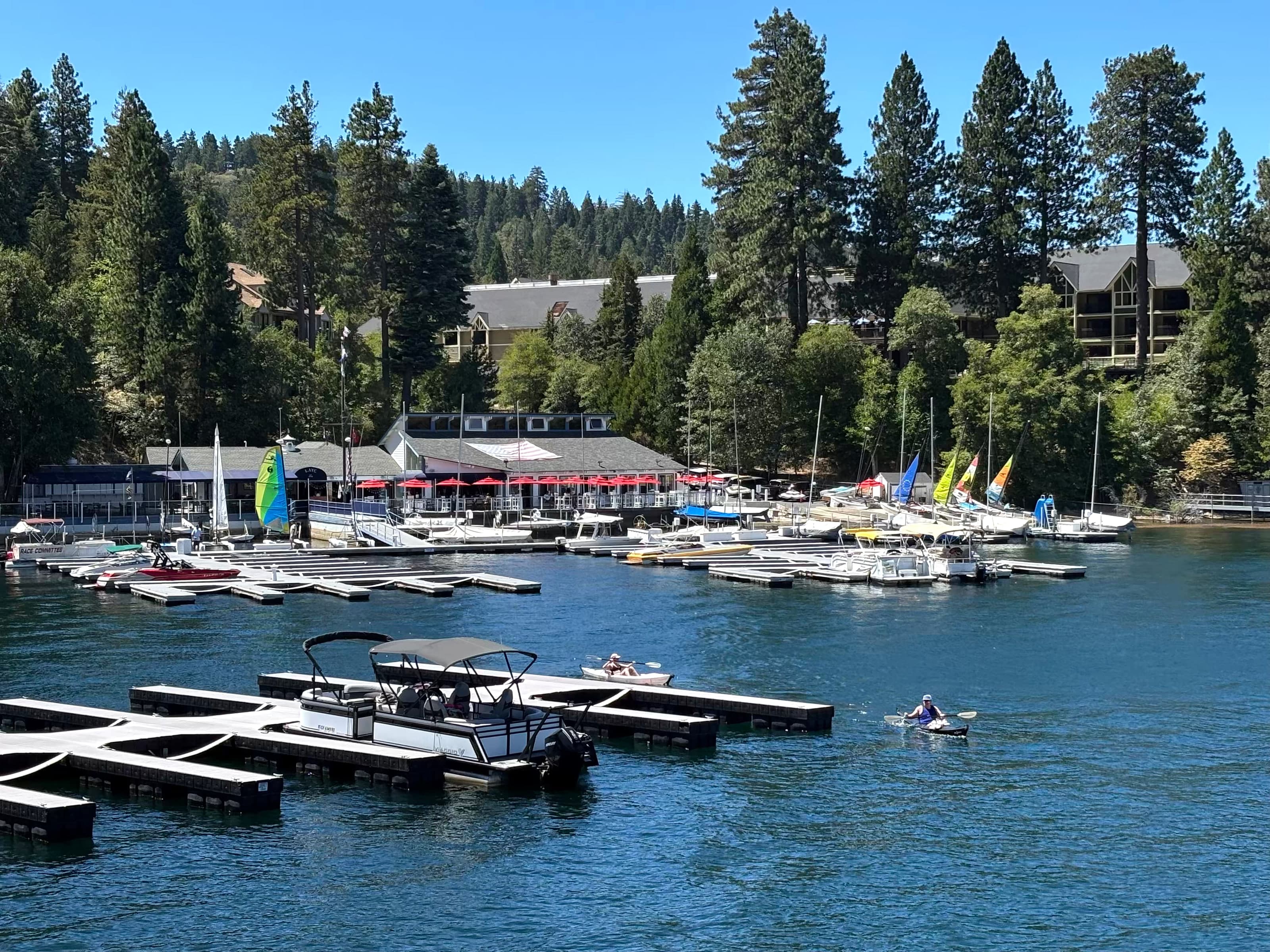 Lake Arrowhead Village marina with sailboats, docks, and red umbrellas