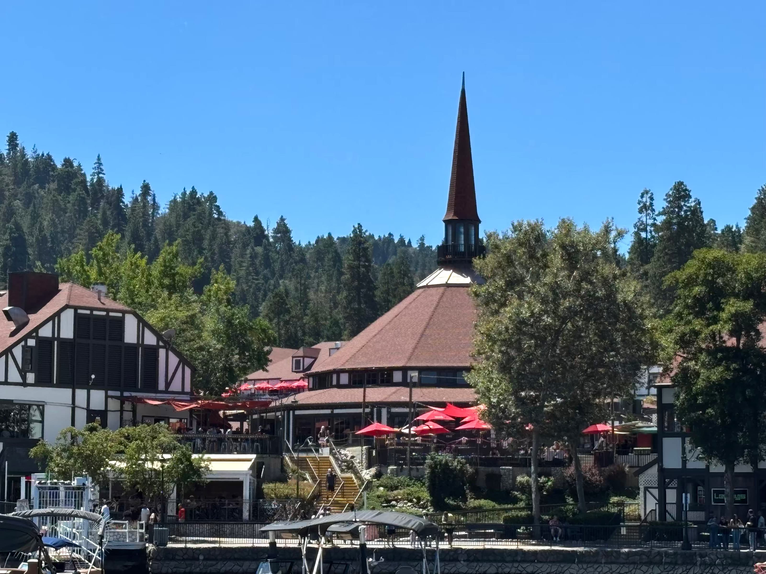 Lake Arrowhead Village spire and red umbrellas above the waterfront docks