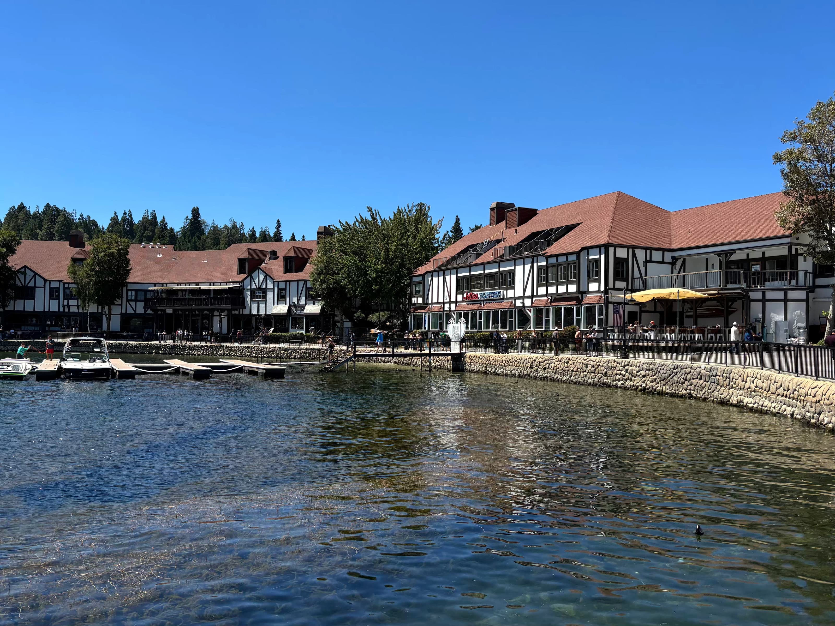 Tudor shops at Lake Arrowhead Village along the lake with a stone retaining wall