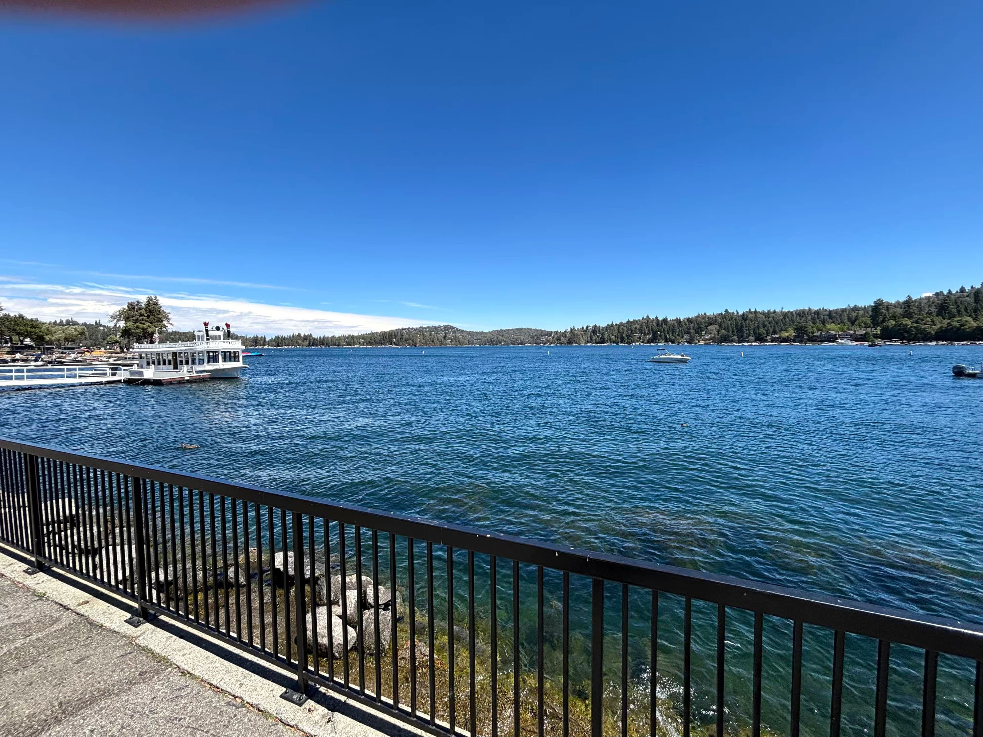 Lake Arrowhead from a Village walkway railing with the tour boat and forested far shore