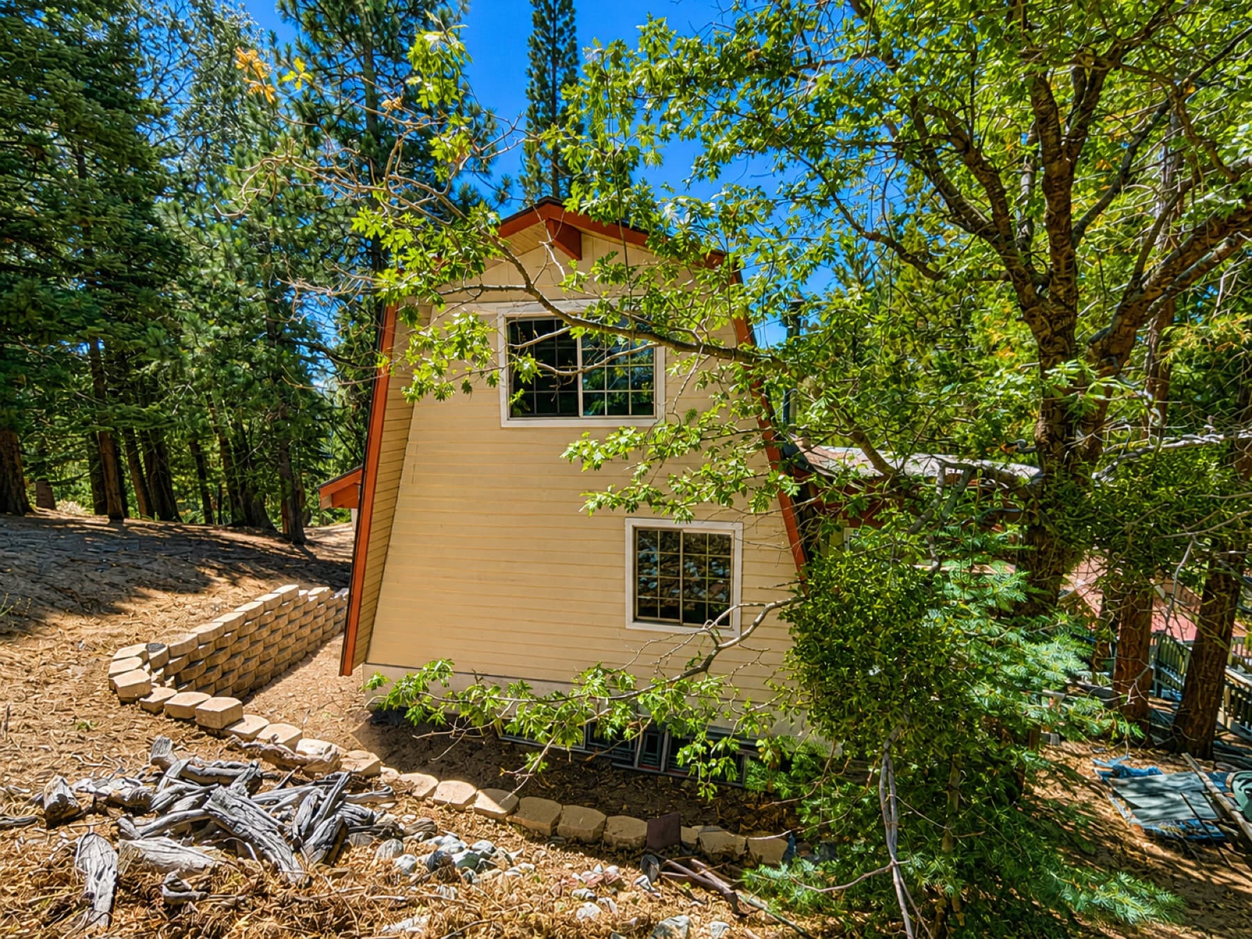 Mountain cabin and retaining wall among pines in Running Springs
