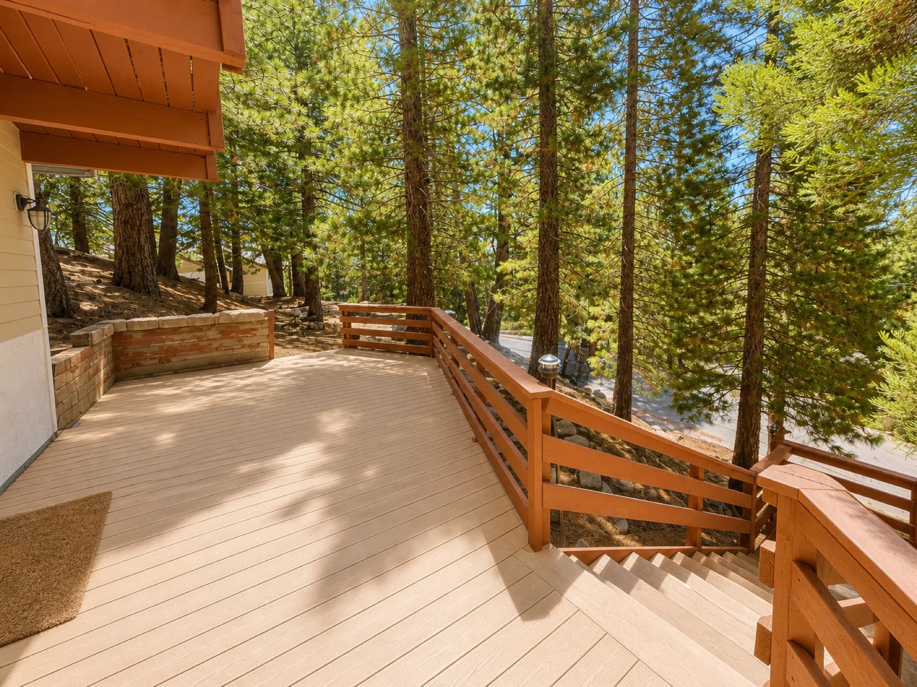 Wooden deck among pine trees on a hillside above a paved mountain road