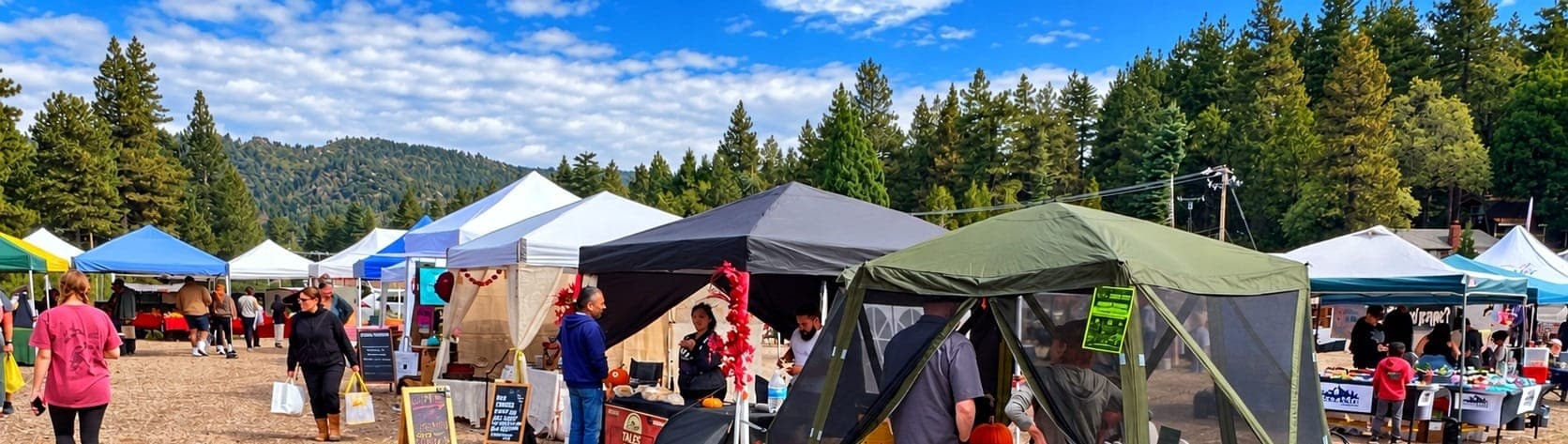 White vendor tents under tall pines and blue sky at the Running Springs farmers market