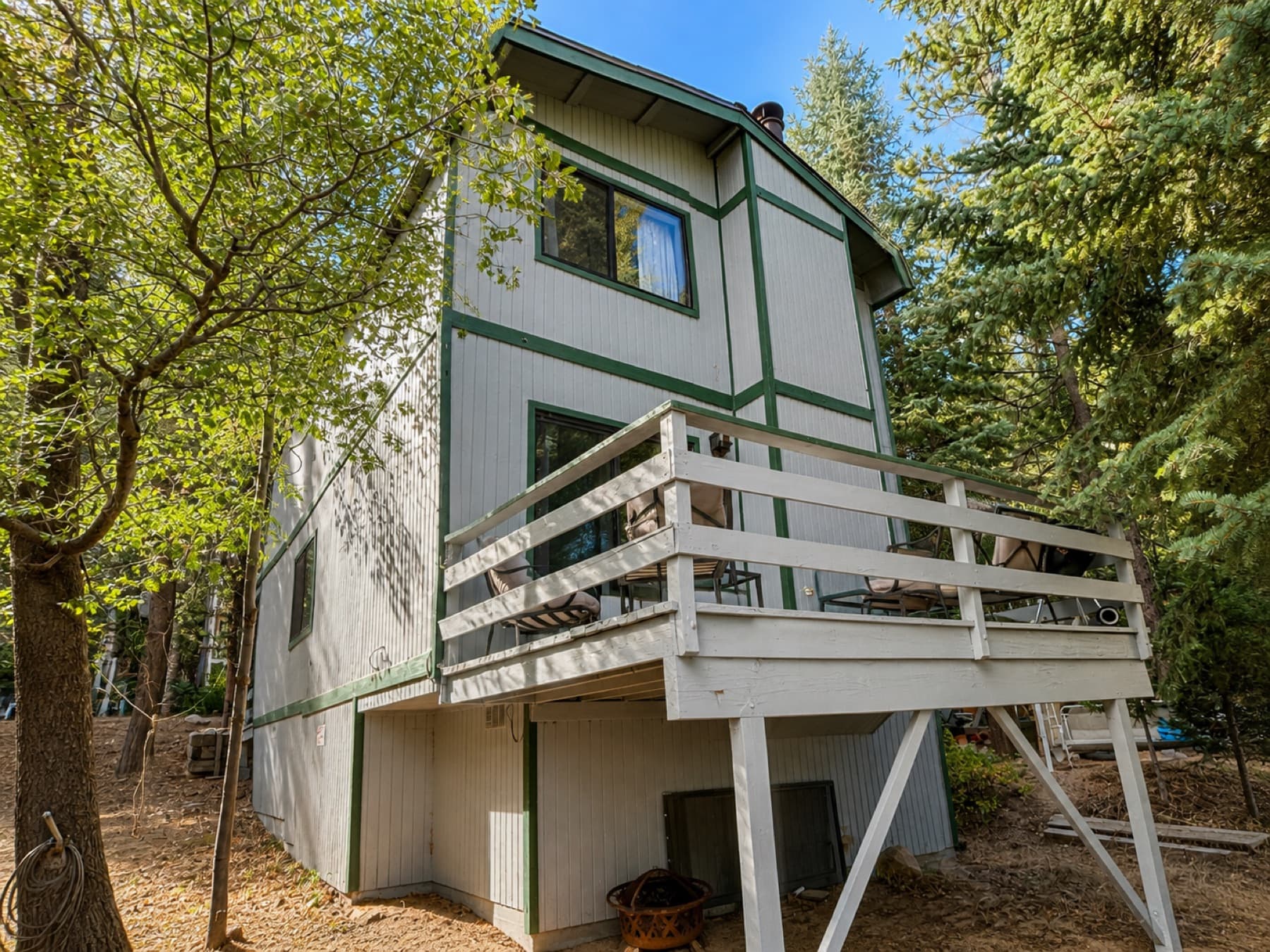 Mountain house and deck on a sloped lot among pines in Running Springs
