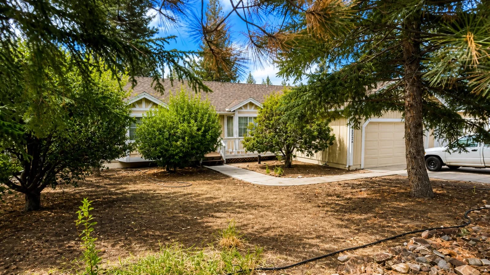 Side of a single-story house with an attached garage and a level concrete driveway.